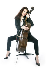 Obraz na płótnie Canvas beautiful brunette woman hugs cello in studio against white back
