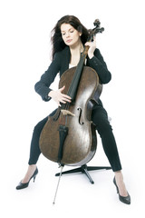 beautiful brunette woman plays the cello in studio against white