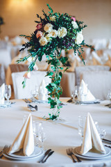 Beautiful bouquet made of white roses and dark greenery stands i