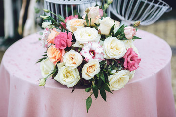 Bouquet of pink and white roses lies on pink table