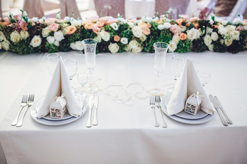 Look from above at white serviettes on dinner plates and green g