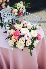Stunning bouquet of roses stands on table with pink cloth