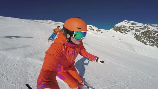 4k skiing footage, action cam selfie perspective woman and two men skiing down ski piste 
