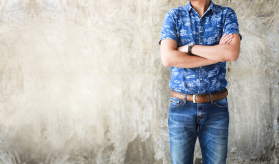 Closeup Men casual outfits denims standing and cross one's arm. Concrete background with space for texture. men beauty and fashion concept, Jeans concept