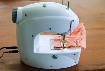 Modern sewing machine on wooden table