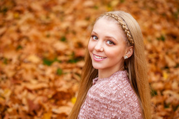 Close up portrait of young blonde beautiful woman in autumn park