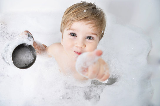 small child takes a bath with foam