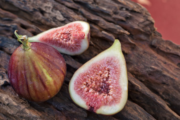Whole and cutted fresh figs on rustic vintage wooden table