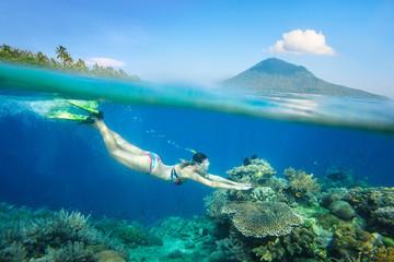 femme plongée en apnée au-dessus du beau récif de corail