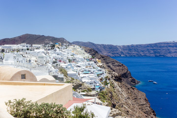 Beautiful view with traditional white buildings over the village of Oia at the Island Santorini, Greece on the Mediterranean sea and rock background