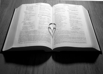 Still life with wedding ring in book,which casts a shadow in the shape of heart