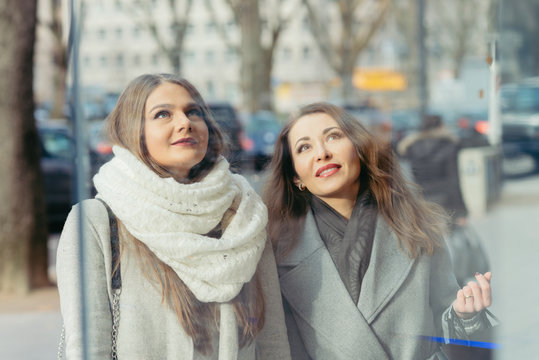 two girls looking at  showwindow