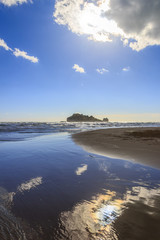 Gargano coast: Portonuovo or Gattarella seascape,Vieste-(Apulia) ITALY-Islet between waves dominated by cloud crossed by sunbeams.Sandy beach during a storm.