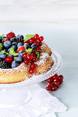 Sponge cake with fresh berries on white table with free text space.