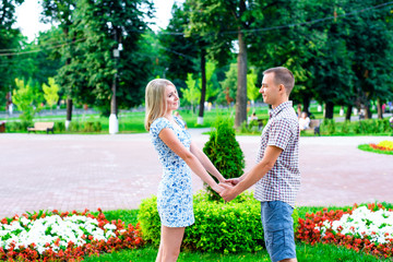 Young couple standing in park ribbon holding each other's hands, a declaration of love,  gentle hug, concept  family,  happy marriage. Lifestyle in city. Outdoors.