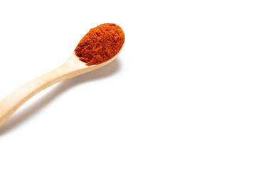 Chili powder in a wooden spoon isolated over white background