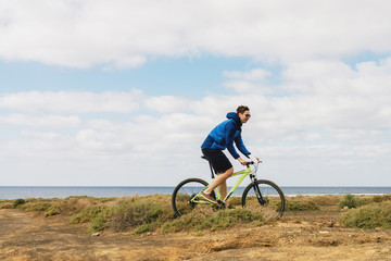 Fototapeta na wymiar handsome man in casual outfit ride a mountain bike on island