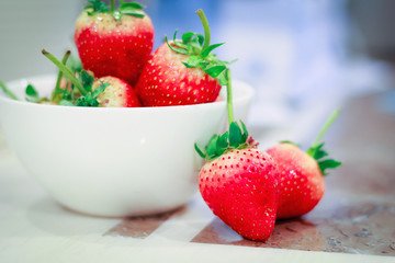 Fresh strawberries in a bowl on table.