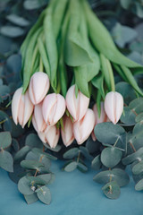 Flower decoration. Fresh pink tulip flowers bouquet on eucalyptus leaves.