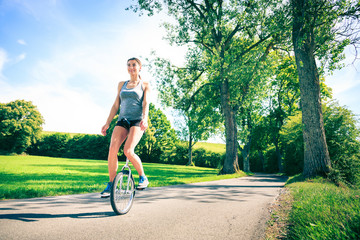 Young Woman Riding Her Unicycle © nullplus