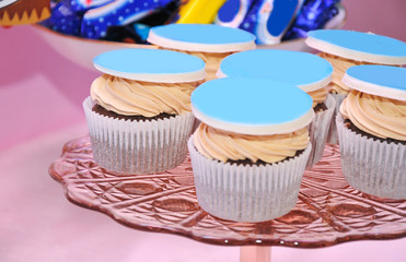 Closeup of cake on a children's holiday in the background. 
