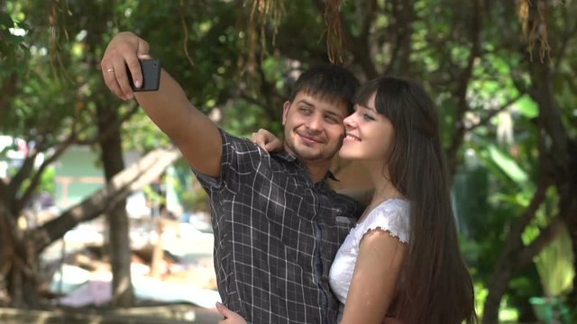 Smart phone selfie - couple taking self portrait using smartphone camera. Dating couple in love having fun taking candid fresh picture photo laughing smiling