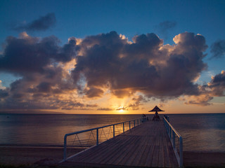 A pier on the sea with sunset in the...