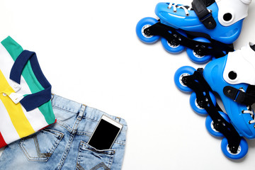 Sport, healthy lifestyle, roller skates and boy's clothing set, cell phone on white background