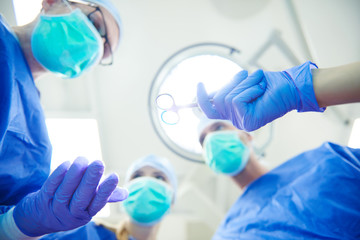 Focus doctors passing medical scissors