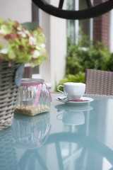 Kaffeetasse auf einem Tisch aus Glas.