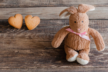 Fluffy toy bunny with cookies in the shape of hearts.  Postcard