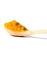 Turmeric powder in a wooden spoon isolated over white background