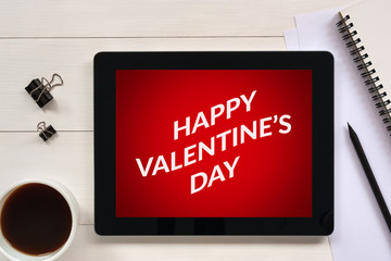 Valentine's day concept on tablet screen with office objects on white wooden table. All screen content is designed by me. Flat lay