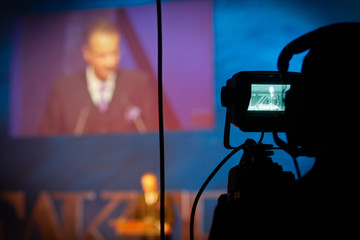 live camera filming an panel lecture shown in it´s display