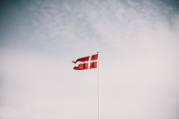 Danish national flag waving on the blue sky background
