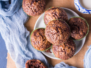 Chocolate banana muffins with sugar topping on dark blue background. Home made single portion snack. Winter baked dessert