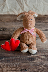 Fluffy toy bunny with felt hearts.  Postcard to Valentine's Day.