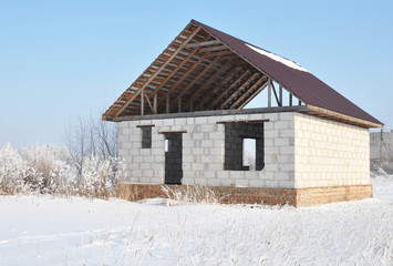 House construction in winter. Unfinished home roofing metal tiles. Roofing Construction.