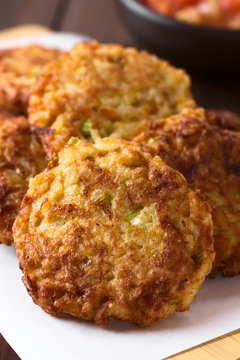 Rice patties or fritters made of cooked rice, carrot, onion, garlic and celery stalks, photographed with natural light (Selective Focus, Focus on the middle of the first patty)