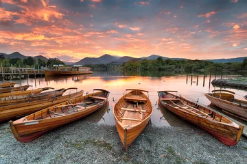 Foto auf Acrylglas See / Teich Ein feuriger Sonnenuntergang über Booten am Ufer des Derwentwater in Keswick im Lake District in Cumbria