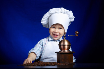 little boy plays with coffee mill
