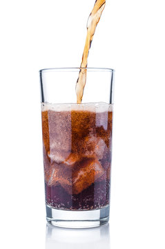 Pouring cola into glass with ice cubes on white background