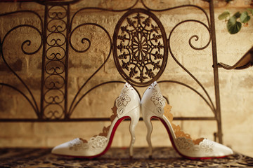 White wedding shoes stand side by side on the steel bench