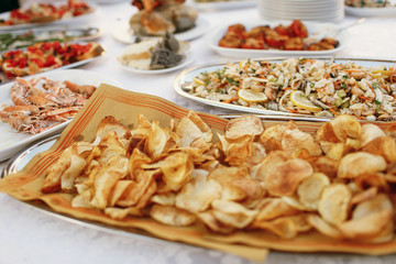 Potato chips stand served on white dinner table