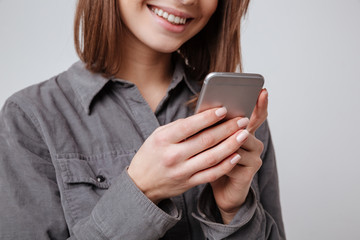 Fototapeta premium Cropped image of happy young woman using mobile phone.