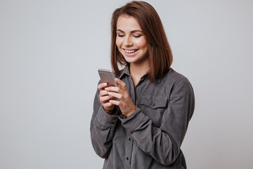 Happy young lady using mobile phone.