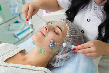 The patient receives procedure Darsonvald. His face is smeared with gel.