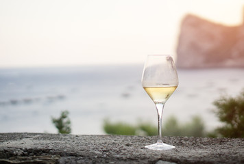 A glass of white wine, on background the sea of Massalubrense near Sorrento