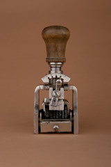 Vintage date stamp. Industrial office stamp. Old numbering machine isolated on brown.