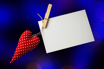 Red toy heart and blank card on black